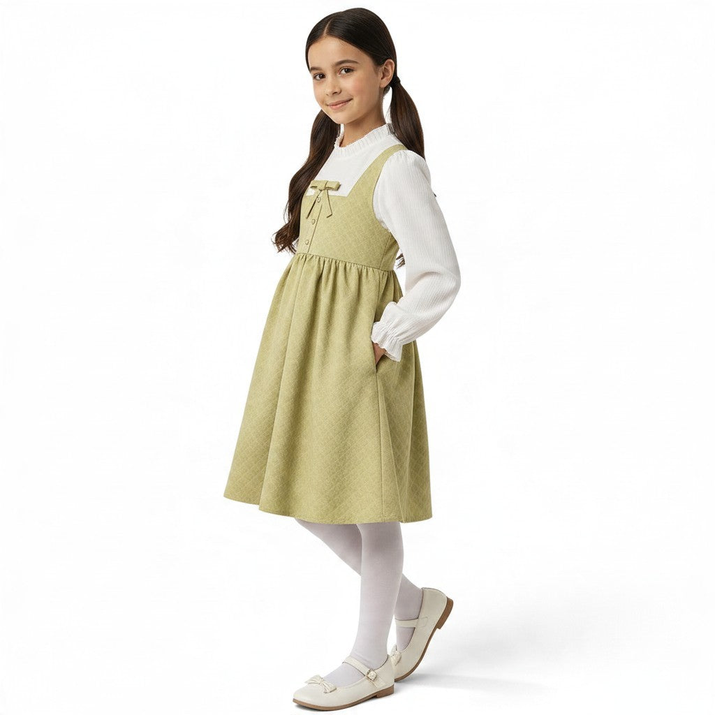 JOANNA FASHION sage green quilted pinafore dress with bow detail and side pockets worn by a young girl