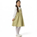 JOANNA FASHION sage green quilted pinafore dress with bow detail worn by a young girl with a white blouse and tights.