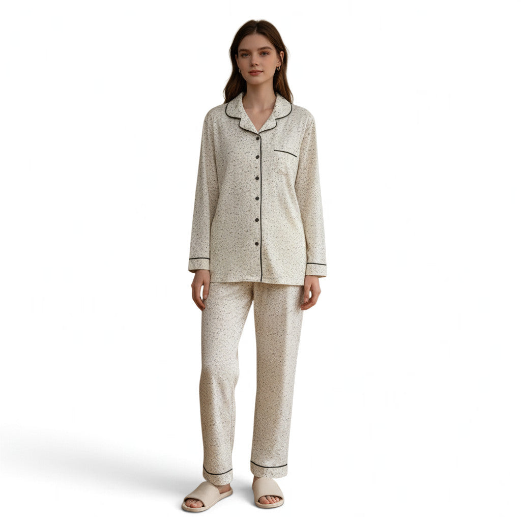 Model wearing a JOANNA FASHION long-sleeve button-down pajama set in cream with a delicate black speckled print.
