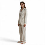A model wearing a JOANNA FASHION speckled print long-sleeve button-down pajama set with black piping and trousers.