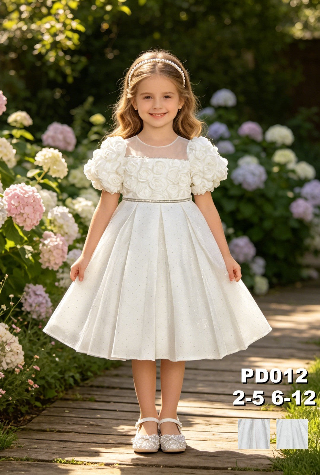 JOANNA FASHION white flower girl dress with floral applique bodice, puff sleeves, and rhinestone belt in a garden
