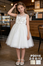 JOANNA FASHION white flower girl dress with sheer neckline, oversized floral applique, and shimmering tulle skirt.